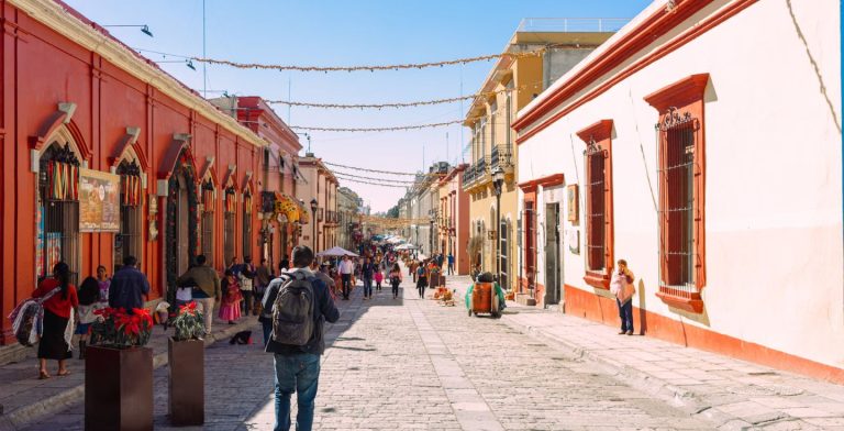 Eine typische Straße in einer Stadt in Mexiko mit Gebäuden in traditioneller Architektur.