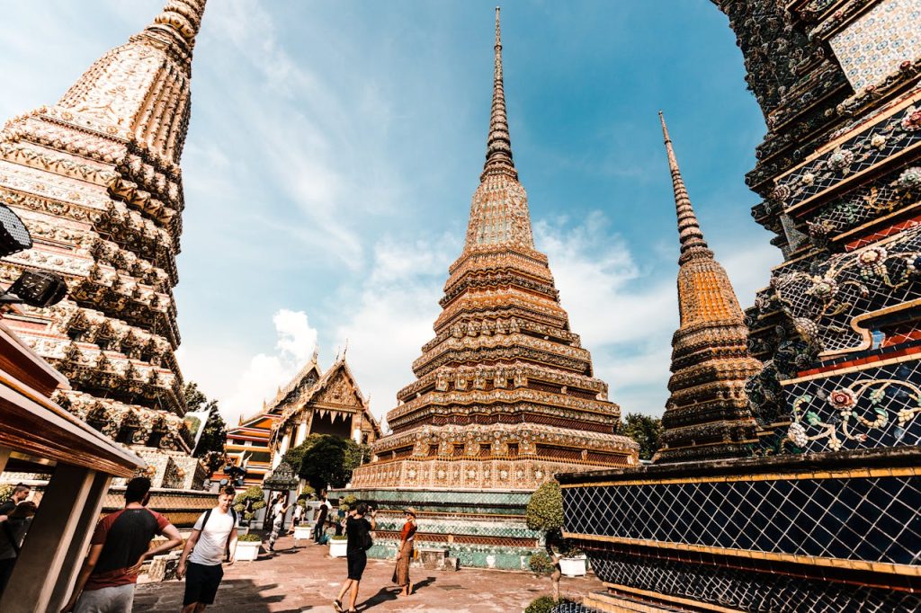 Touristen besuchen eine Tempelanlage in Thailand.