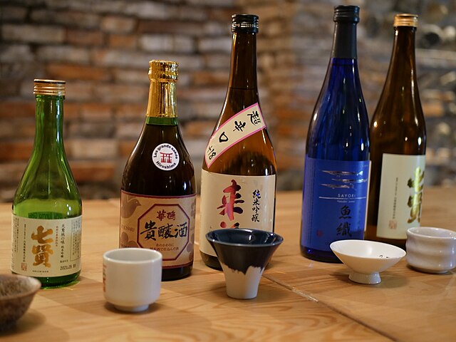 Sake-Flaschen und Gläser auf einem Tisch.
