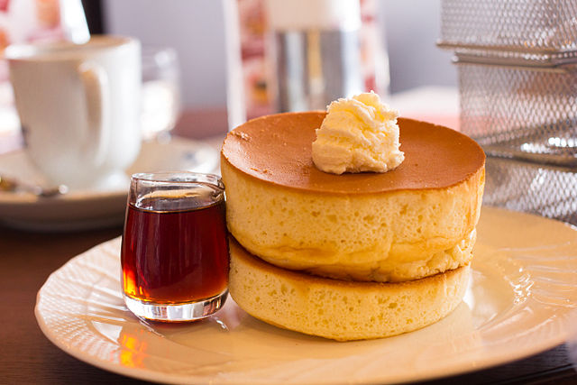 Ein Soufflé-Pfannkuchen, bekannt als Jiggly, auf einem Teller mit etwas Schlagsahne oben drauf.