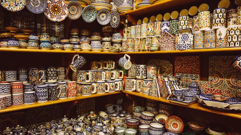 Des étagères remplies de tasses et d'asxsiettes colorées, typiques du Maroc.