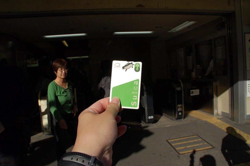 Une personne tenant une carte Suica.