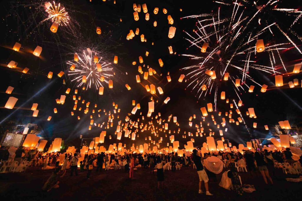 Des lanternes et des feux d'artifices dans le ciel pendant le festival de lancer de lanternes en Thaïlande