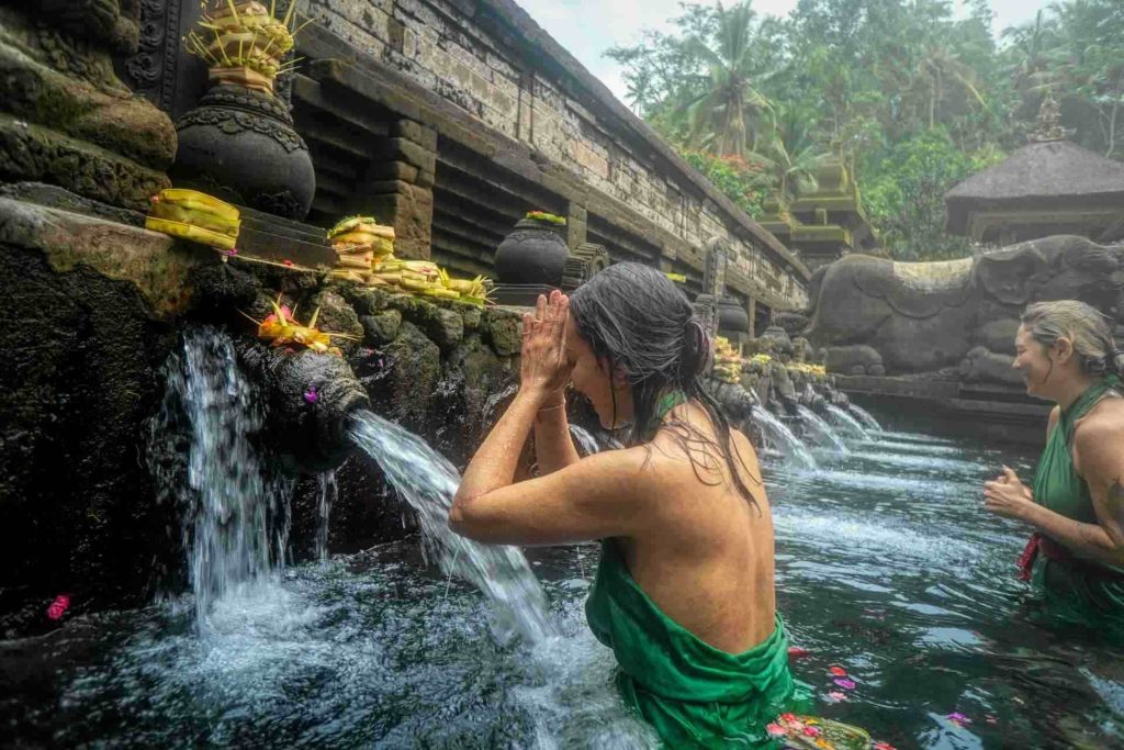 Donne di fronte a un corso d'acqua in un luogo tradizionale di Bali, in Indonesia.