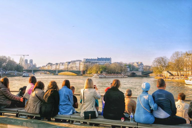 Gruppo di viaggiatori osserva un ferry turistico sulla Senna a Parigi, in Francia.