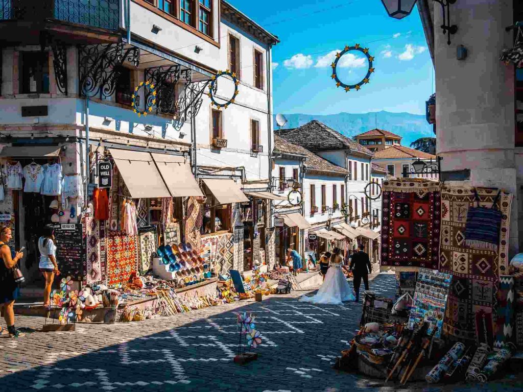 Turisti osservano una coppia che si fa scattare le foto di matrimonio per le strade di Gjirokastër, in Albania.