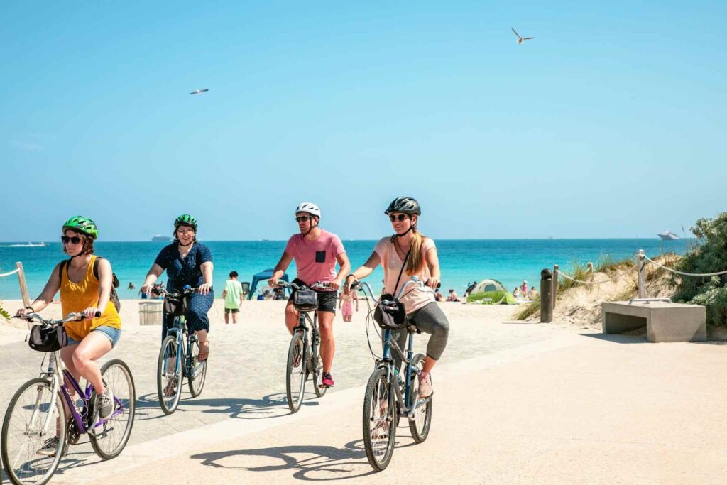 Gruppo di giovani in bicicletta sulla spiaggia di Miami