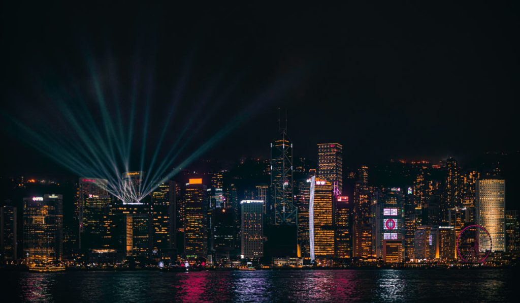 香港の夜景を映した写真。ビクトリアハーバー沿いにそびえる高層ビル群がライトアップされている。