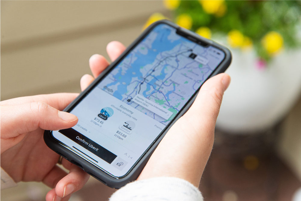 スマートフォンでUberアプリを操作し、車両を選択している手元の画像