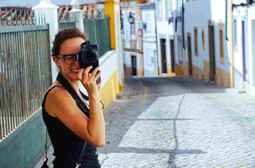 Uma turista tirando fotos em Lisboa.