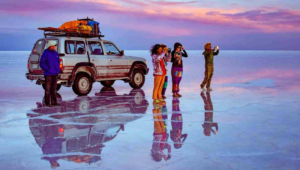 Turistas conferindo o efeito espelho, no Salar de Uyuni.