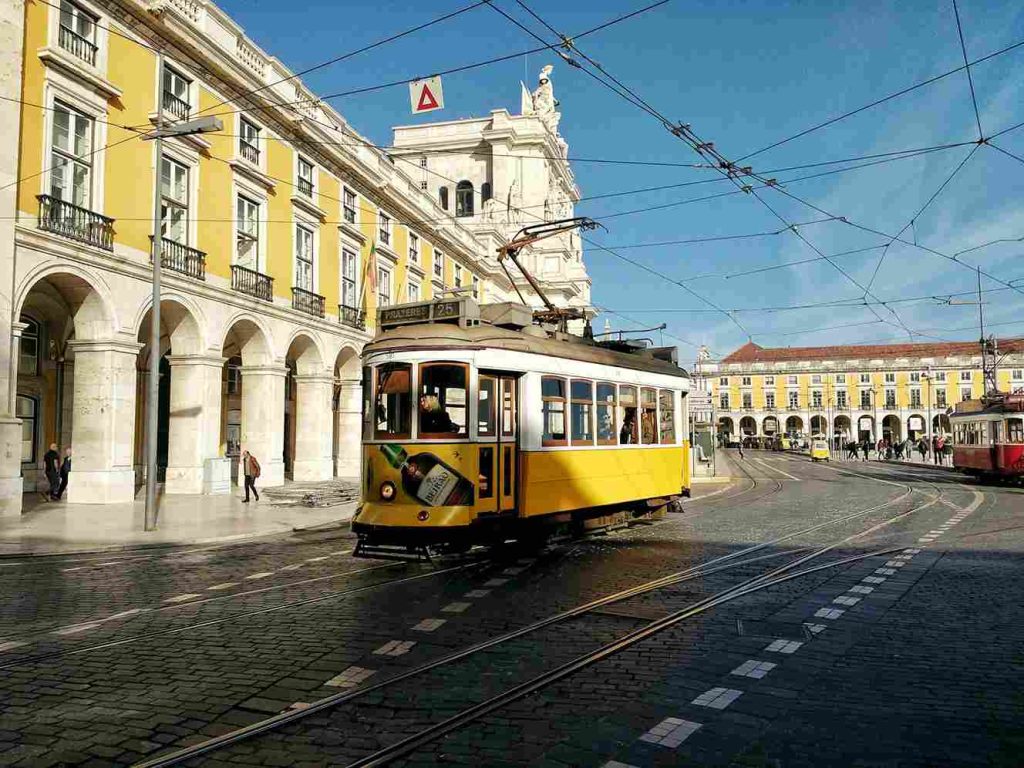 um bondinho percorrendo um trecho no centro de Lisboa, Portugal.