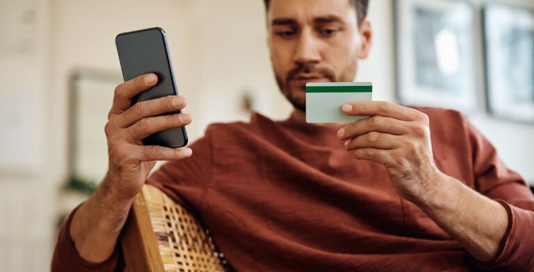 man entering his credit card details into his eSIM-phone