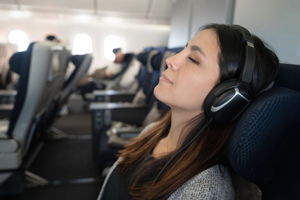 woman with headphones on an airplane