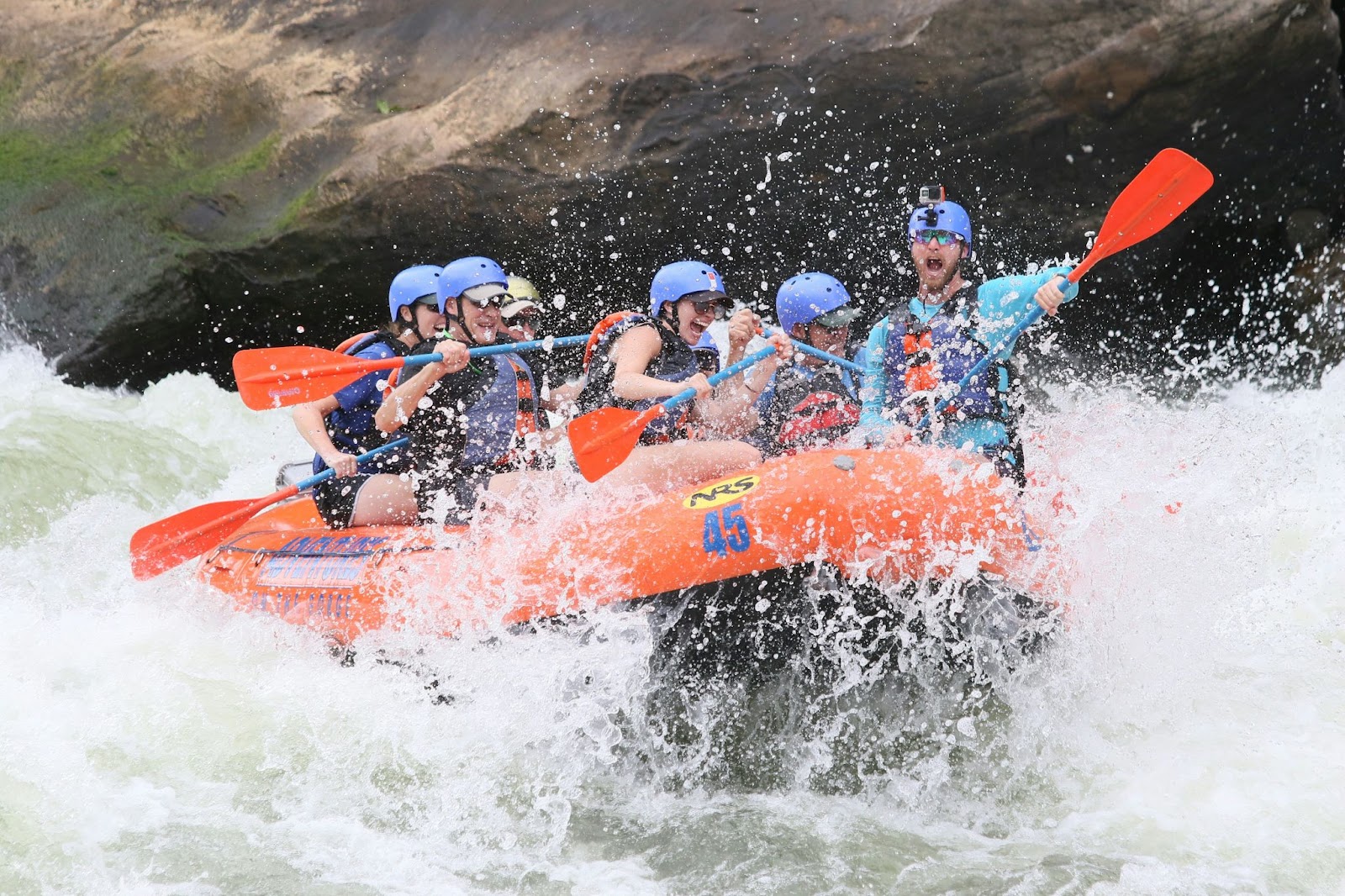 A group of friends whitewater rafting down a river in Costa Rica