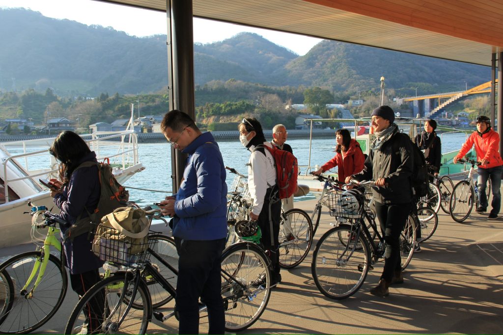 People on bikes trailing on a bike route called the Shimanami Kaido outside of Hiroshima