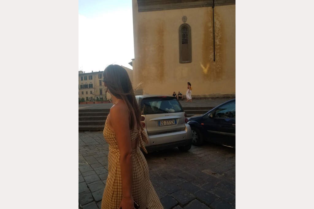 A woman walking the streets of Florence. 